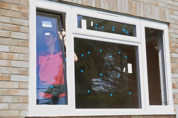 Technician installing home window glass