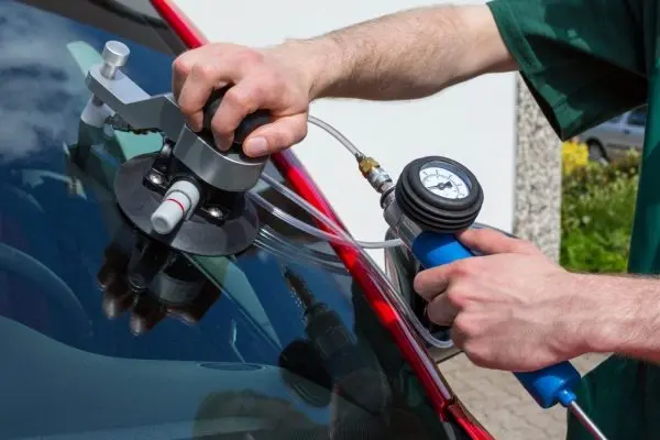 Windshield chip repair injector and pressure gauge in use